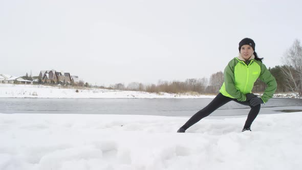 Active Woman Stretching Legs Outdoors in Winter alt
