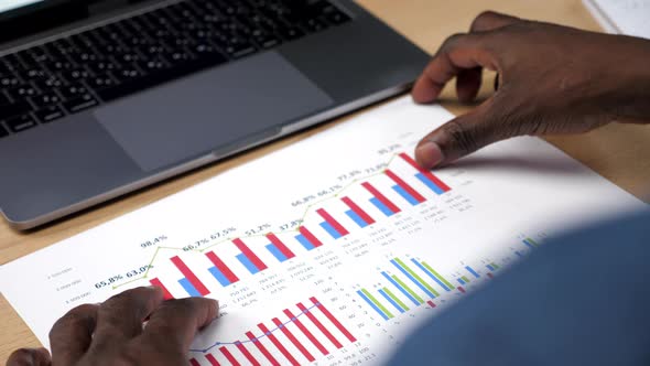 Over the Shoulder African American Businessman Looks Business Report in Office alt
