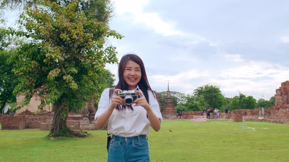 Asian backpacker blogger woman casual with camera walking smiling traveling around pagoda.