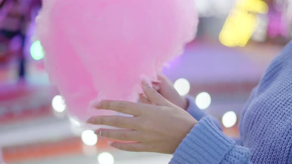 Woman's Hands Touching Sticky Fluffy Pink Candy Floss at a Funfair  Closeup alt
