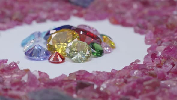 Close Up Colorful Diamonds Are Placed In Raw Pink Gemstones Are Turning alt