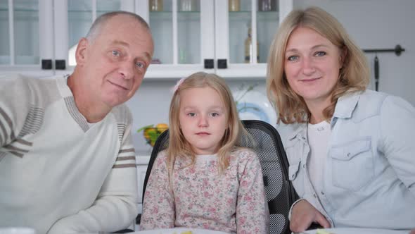 Joyful Family Happy Parents with Their Daughter Have Fun Talking at Table During Dinner in a Cozy alt