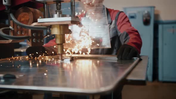 A Professional Worker Behind Protective Glass Works with a Laser Installation