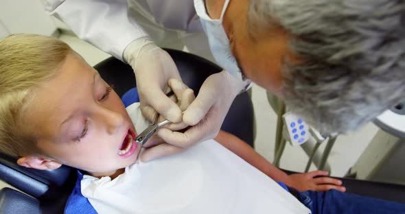 Dentist examining a young patient with tools alt