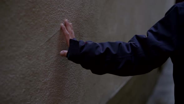 Close-up of a Child's Hand in a Blue Jacket. the Child Walks Down the Street and Touches the Wall of alt