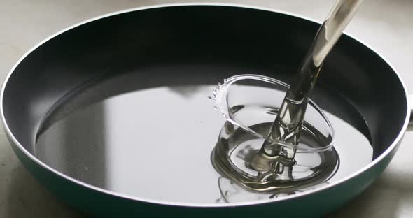 Closeup of Pouring Oil Into a Frying Pan for Cooking