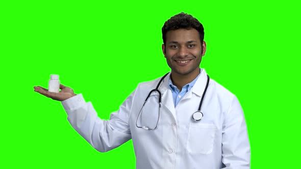 Young Male Doctor Presenting Pills on Green Screen alt