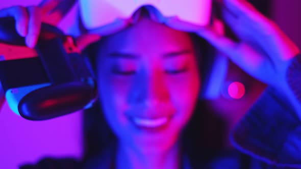 Young asian woman is using virtual reality headset. Neon light studio portrait. alt
