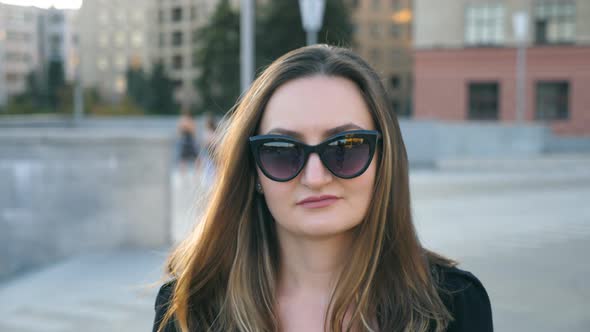 Portrait of Young Businesswoman in Sunglasses Walking in City Street. Attractive Business Woman