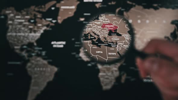 Ukraine on the World Map Under a Magnifier Loupe Worldwide Attention to War alt
