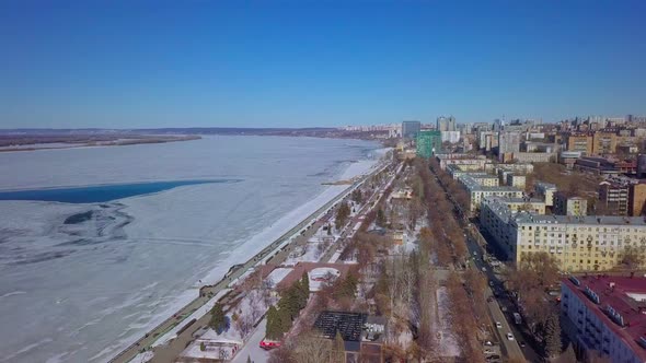 Calm Cityscape at Winter Day Aerial View on Embankment Along River with Ice