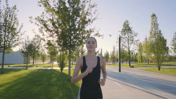 Sports Woman Makes Morning Jog and Physical Exercises In  Park alt