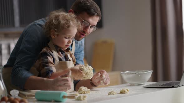 Man and His Little Son are Having Fun at Kitchen Cooking and Playing with Dough Learning to Cook By alt