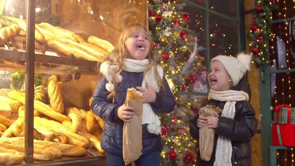 Siblings Eating Bread Near Bakery in Evening