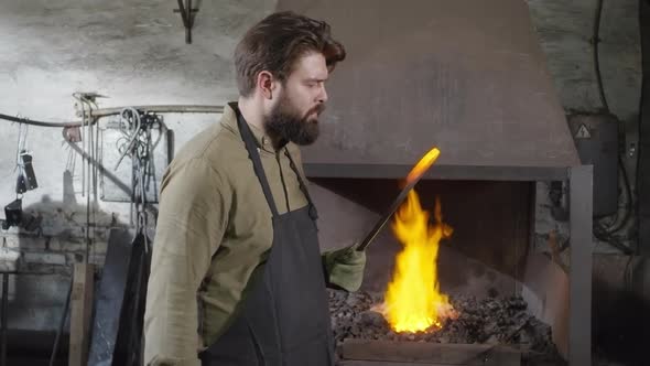 Professional Blacksmith Working in Workshop alt
