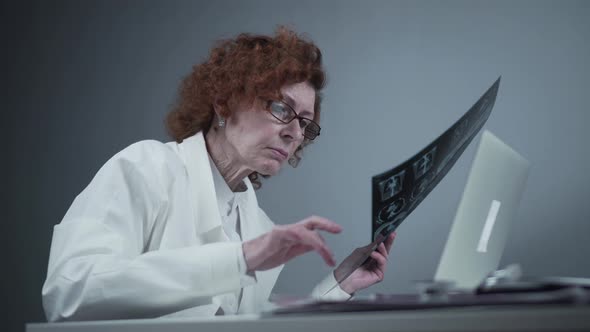 A Senior Woman Doctor is Doing Patient's Chest CT Scan on a Laptop in the Office alt