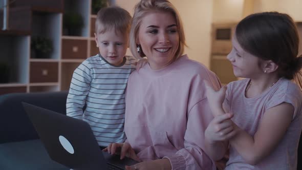 Happy Woman with Her Two Child Using Laptop at Home