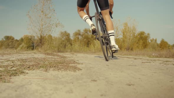 Cyclist Riding On Gravel Bike In Slow Motion. Cyclist Athlete Workout Riding On Gravel Bicycle. alt