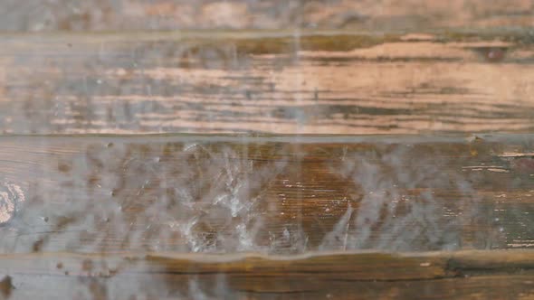 Drops of Water Beat Against a Wooden Surface