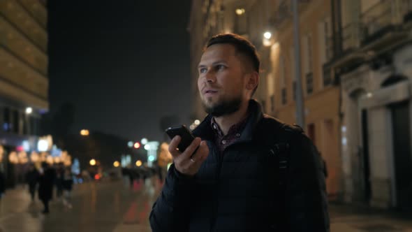 Young Hipster Guy Using Modern Smartphone Outdoors Man Chatting with Friends at Social Networks alt