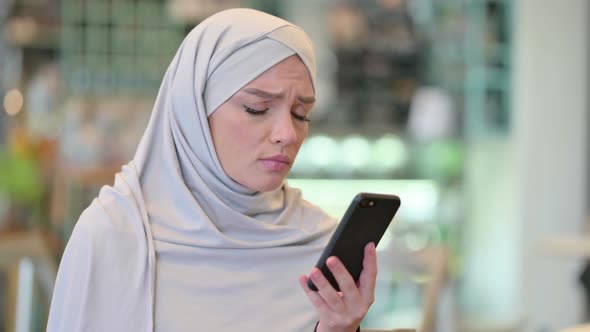 Portrait of Young Arab Woman Having Loss on Smartphone  alt