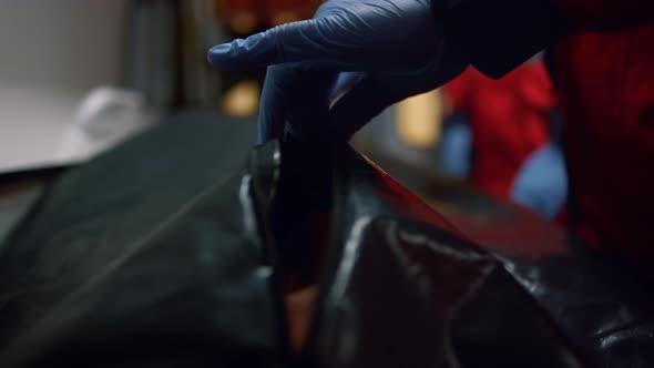 Closeup Paramedic Hands Closing Body Bag with Dead Man After Coronavirus Disease alt