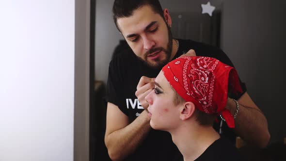 Male visagist use cosmetics for actor theatre. Stylish makeup face man backstage alt