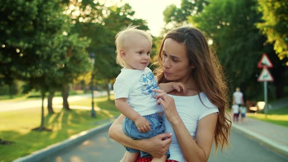 Mother Holding Kid on Hands in Park, Woman and Boy Playing Together Outdoors alt