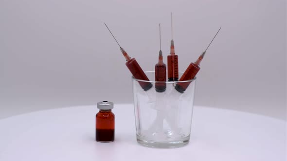 Vaccine bottle with red solution with syringe