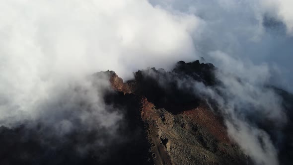 Drone footage of clouds over the summit of the Piton des Neiges at the Reunion island. alt