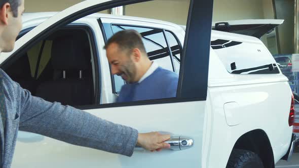 Stylish Seller Opens the Car Door and Invites There Buyer