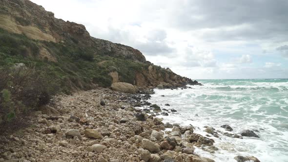 Walking on Rocks near Golden Bay Beach in Winter Time in Malta on a Sunny Windy Day