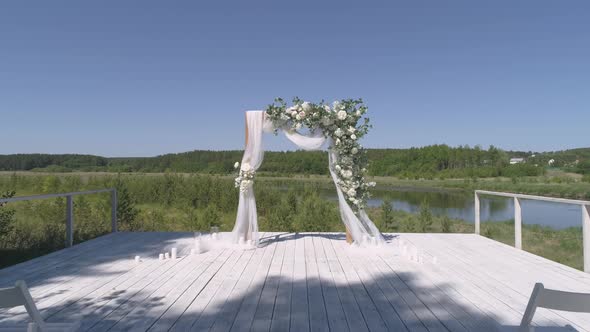 Drone view of wedding arch on the pier by the river next to the forest 33 alt