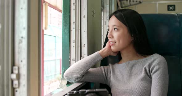 Woman looking out of the window and taking train alt