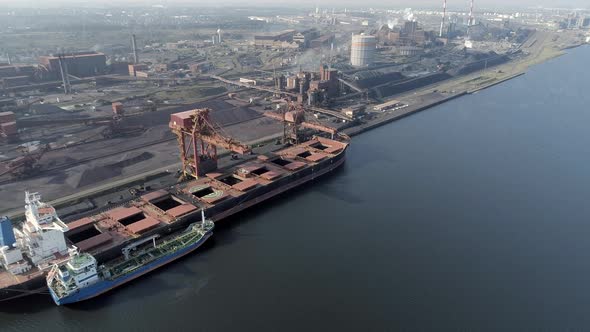 Bulk Carrier Ship Offloading Cargo at an Industrial Port in Europe alt