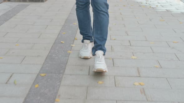 Close Up Shot of Feet of Man Walking on Pavement alt