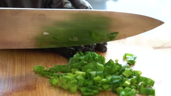 Closeup Shot of Chef in Black Gloves Chopping Spring or Green Onion Parsley and Dill in the Kitchen