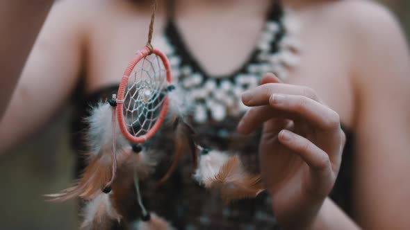 Young Woman Spinning the Dreamcatcher. Close Up. Spirituality and Connection with the Nature Concept alt