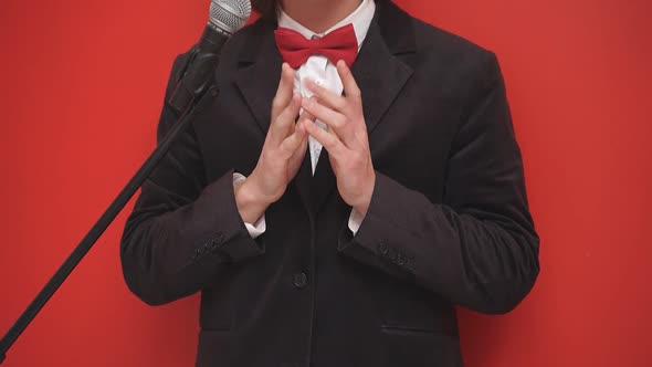 Magician Dressed in a Black Suit with Bright Makeup on His Face Grimaces Arranges a Performance