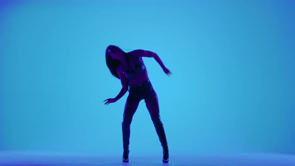 Sexy Brunette in Black Leather Lingerie is Dancing Erotically in a Dark Studio Illuminated By Blue alt