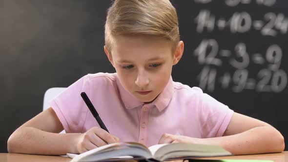 Studious Pupil Writing Test Work, School Lessons, Math Equation on Blackboard alt