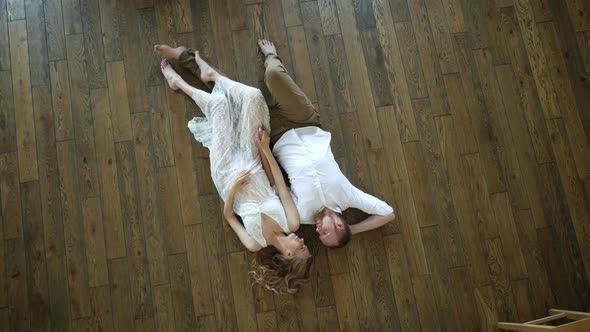 beautiful man with woman lie on the floor top view alt