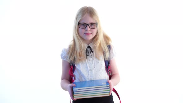 Beautiful Schoolgirl with a School Backpack and Wearing Glasses Posing in the Studio on a White