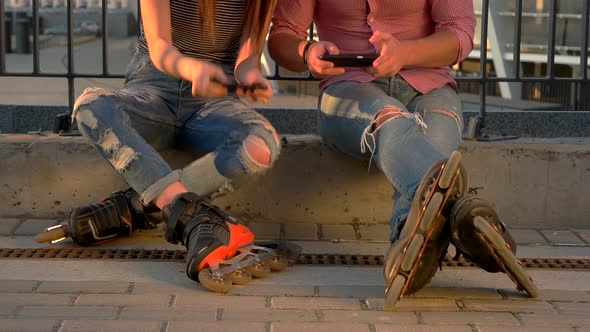 Couple on Rollerblades Is Sitting. alt