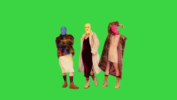 Young Daring Girls in Balaclavas Taking Different Poses in Front of Camera on a Green Screen Chroma
