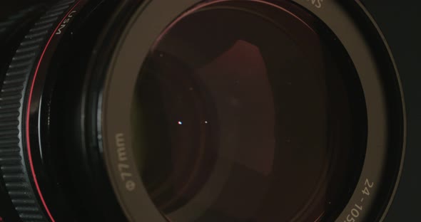 Camera zoom. Closeup shot of professional video camera, with its lens zooming in and out. alt