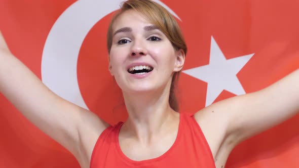 Turkish Young Woman celebrating while Holding the Flag of Turkey alt