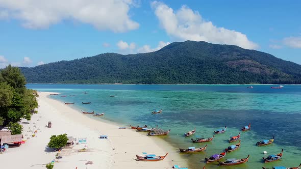 Aerial View of Topical Beach with White Sand Wooden Longtail Boats and Island alt