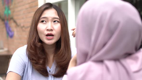 Asian woman talking and smimling with friend at cafe