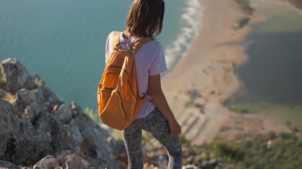 Buautiful Woman Hiker Stands on Edge of Cliff Hiking in Mountains Over Beautiful Seashore Iztuzu alt